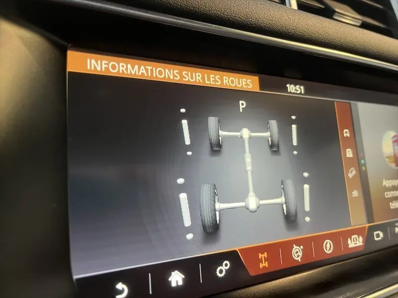 Écran intérieur du Range Rover Sport blanc montrant les informations techniques des roues en mode stationnement.