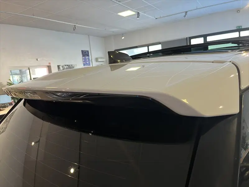 Gros plan sur l'aileron arrière blanc du Range Rover Sport 2018 dans un showroom lumineux.