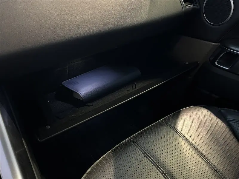 Gros plan sur la boîte à gants ouverte et siège en cuir noir à l'avant droit du Range Rover Sport blanc 2018.