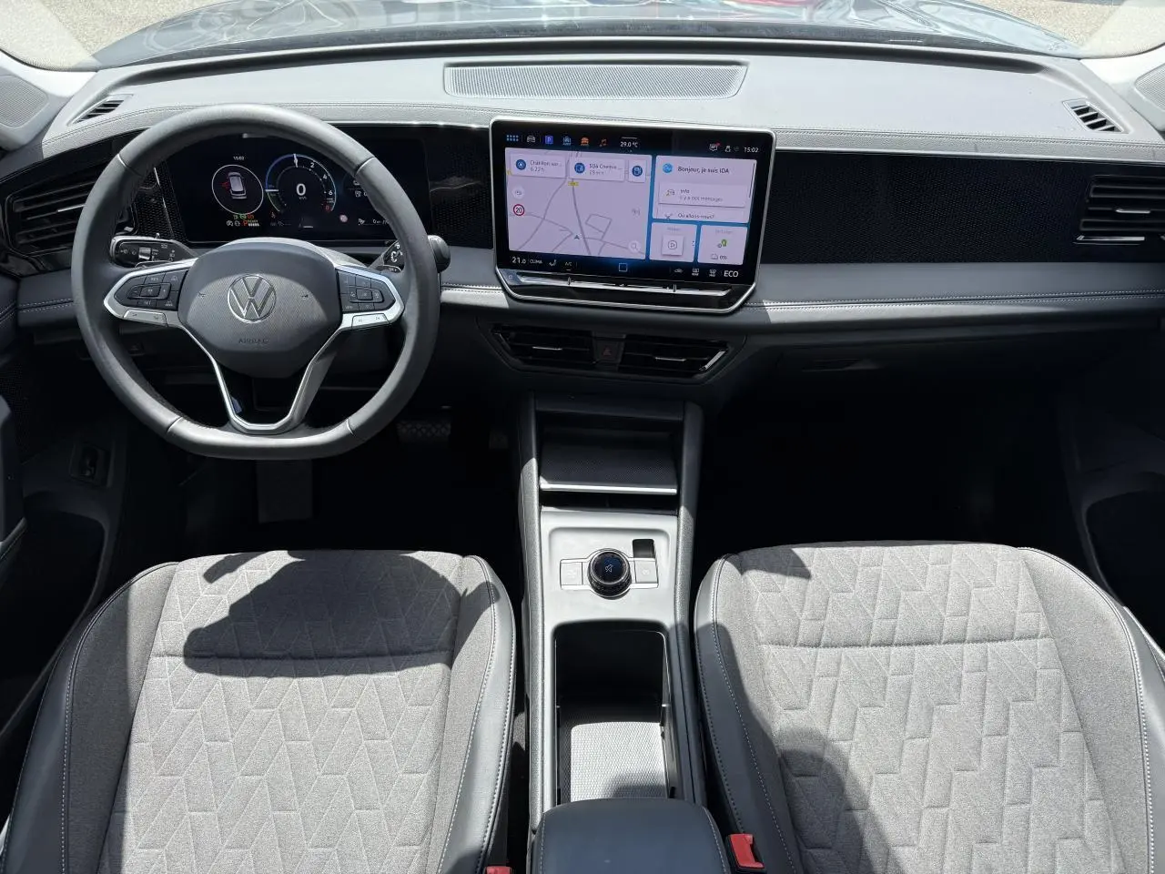 Vue intérieure frontale du Volkswagen Tiguan 1.5 eHybrid 2024 avec tableau de bord numérique et écran tactile central.