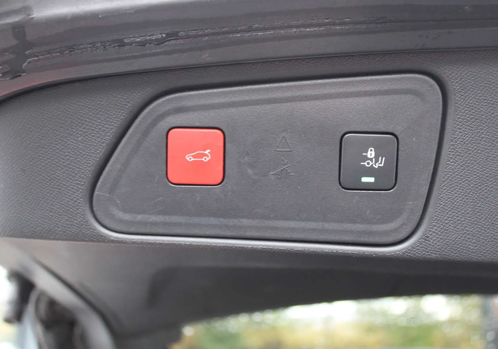 Boutons de commande du hayon électrique sur le bord intérieur du coffre du Peugeot 3008 blanc nacré 2025.