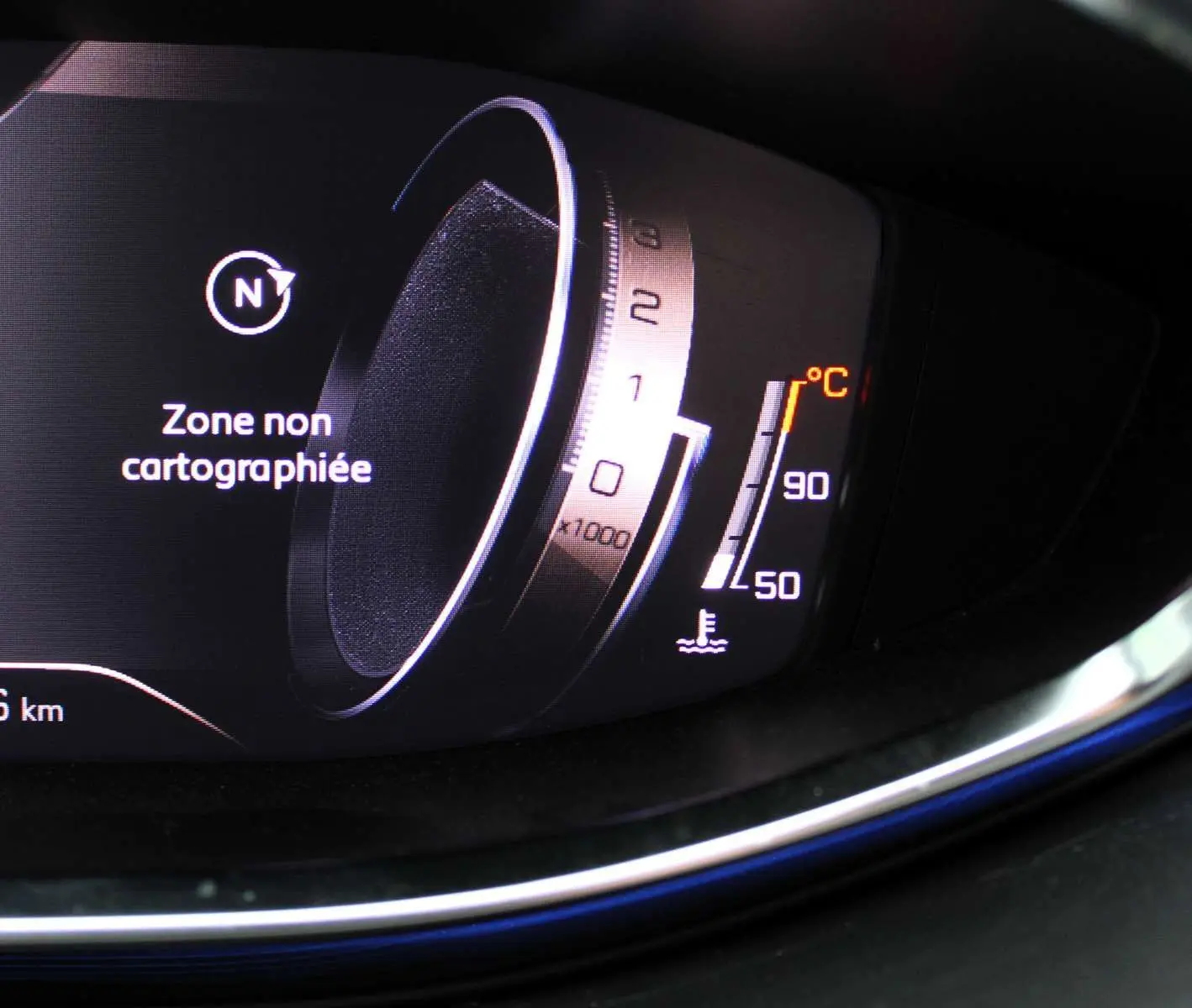 Gros plan sur le tableau de bord numérique du Peugeot 3008 2025, affichant une zone non cartographiée et la température moteur.