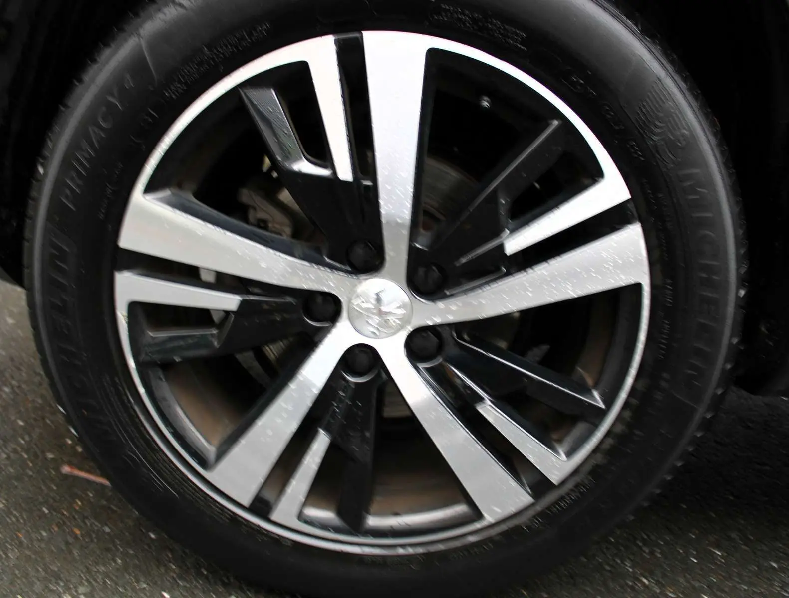 Gros plan sur la jante alliage bicolore du Peugeot 3008 blanc nacré, soulignant son design moderne et élégant.