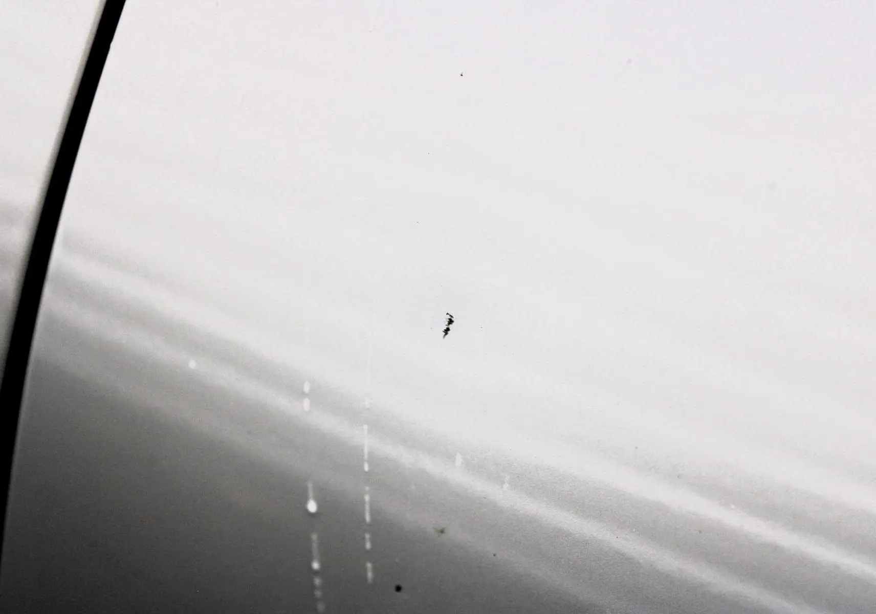 Gros plan sur la peinture blanc nacré du côté gauche d'un Peugeot 3008 2025 avec toit panoramique ouvrant.