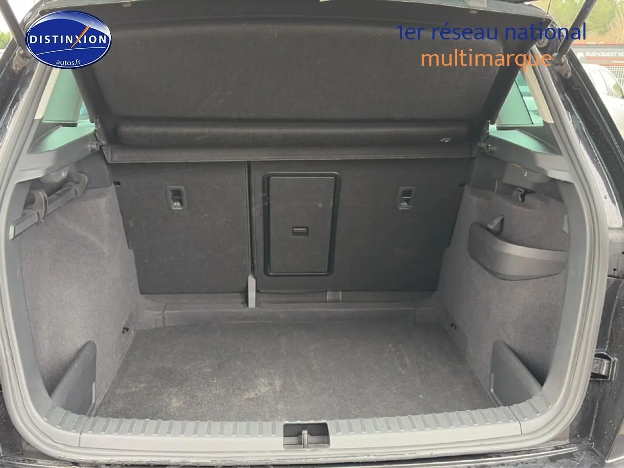 Coffre ouvert vu de l'arrière d'un Skoda Karoq noir, montrant un espace de chargement propre et fonctionnel.