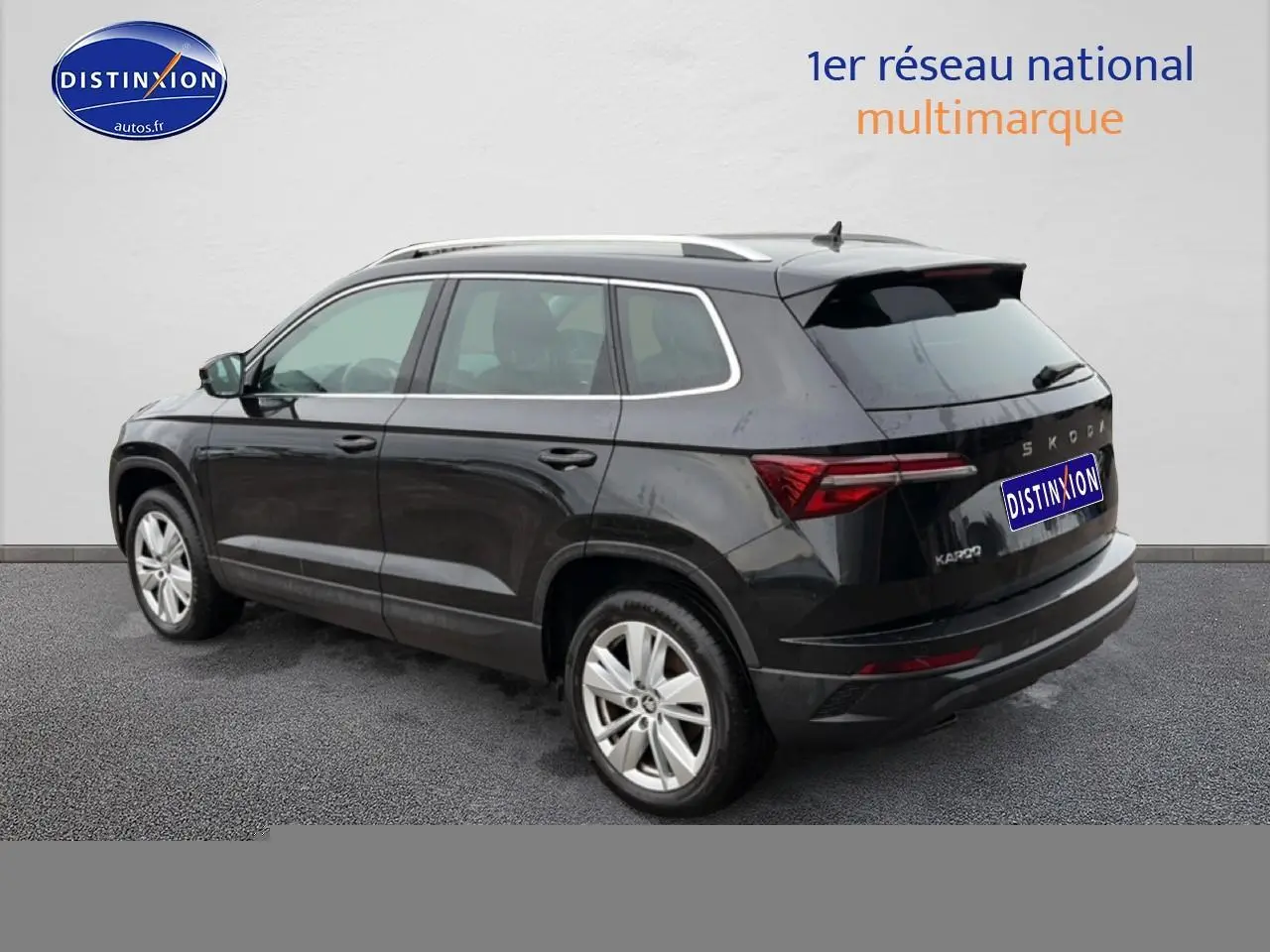 Vue 3/4 arrière droite d'un Skoda Karoq noir 2025 avec barres de toit et feux arrière LED distinctifs.