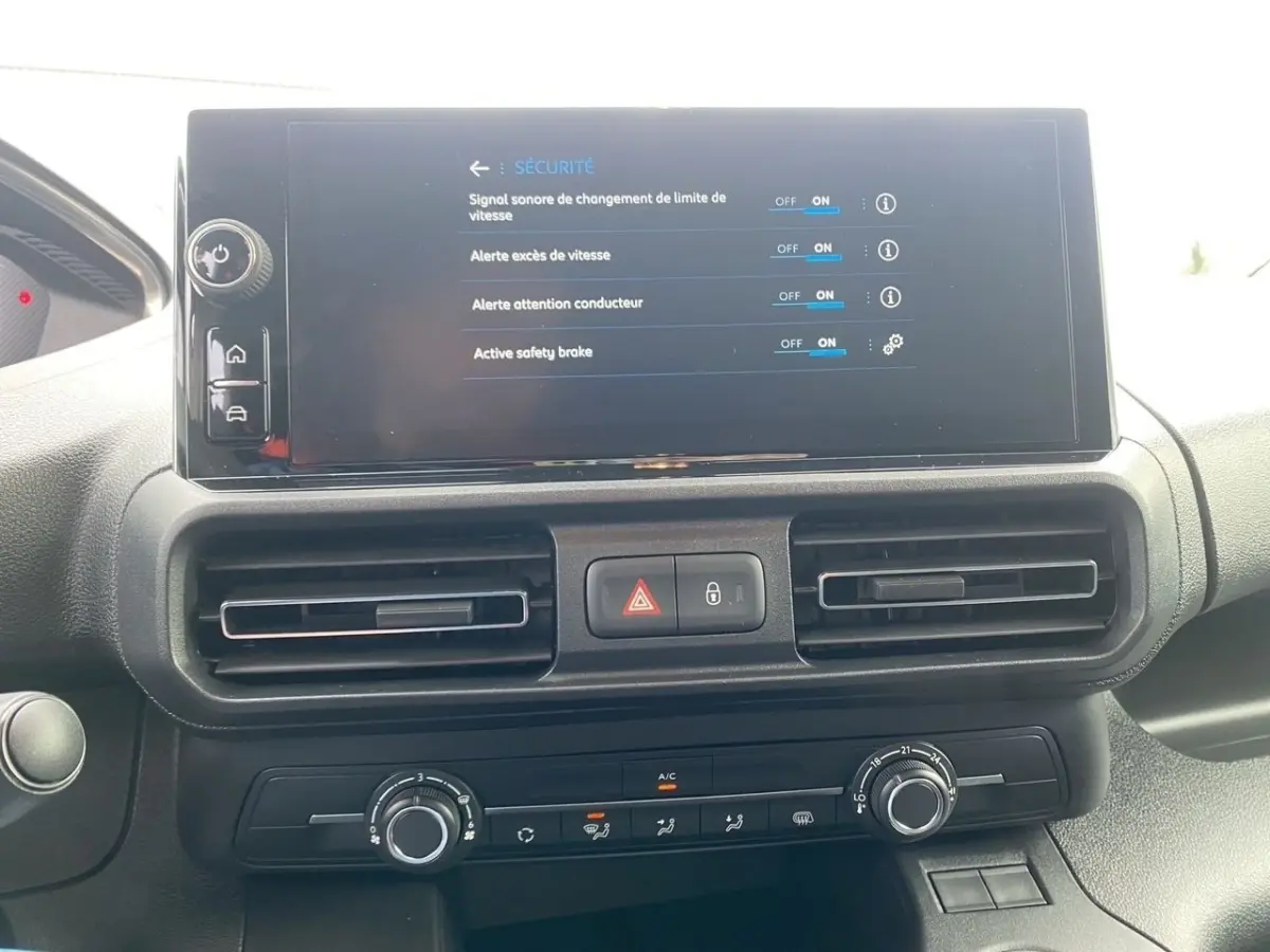 Vue rapprochée du tableau de bord du Peugeot Partner 2024 avec écran tactile affichant les réglages de sécurité.