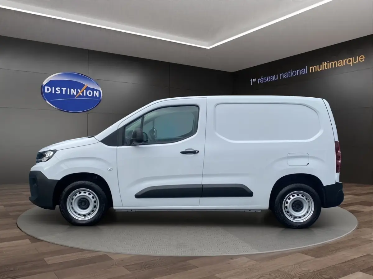 Profil latéral droit du Peugeot Partner blanc 2024 en version utilitaire avec jantes acier et protections noires.