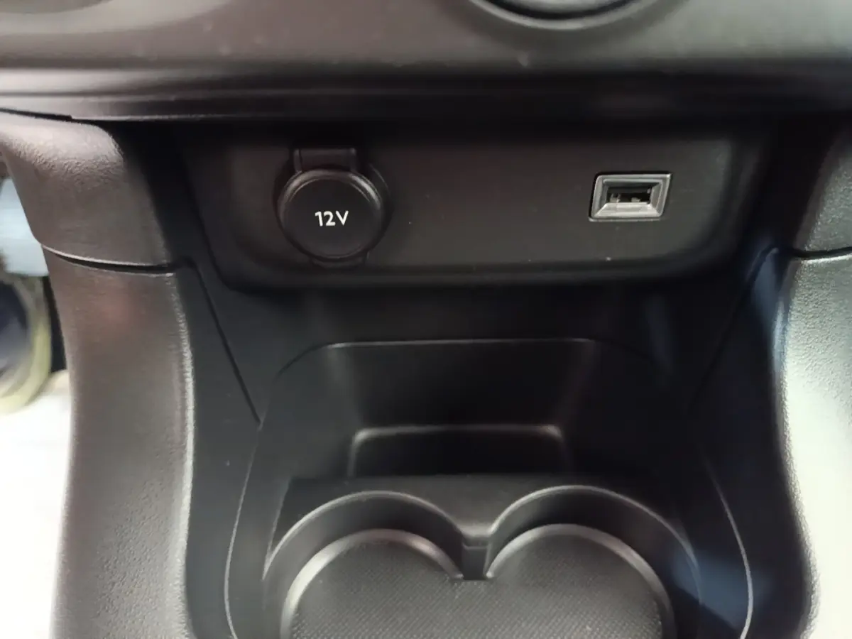 Détail de la console centrale noire de la Citroën C3 avec prise 12V et port USB visible en gros plan.
