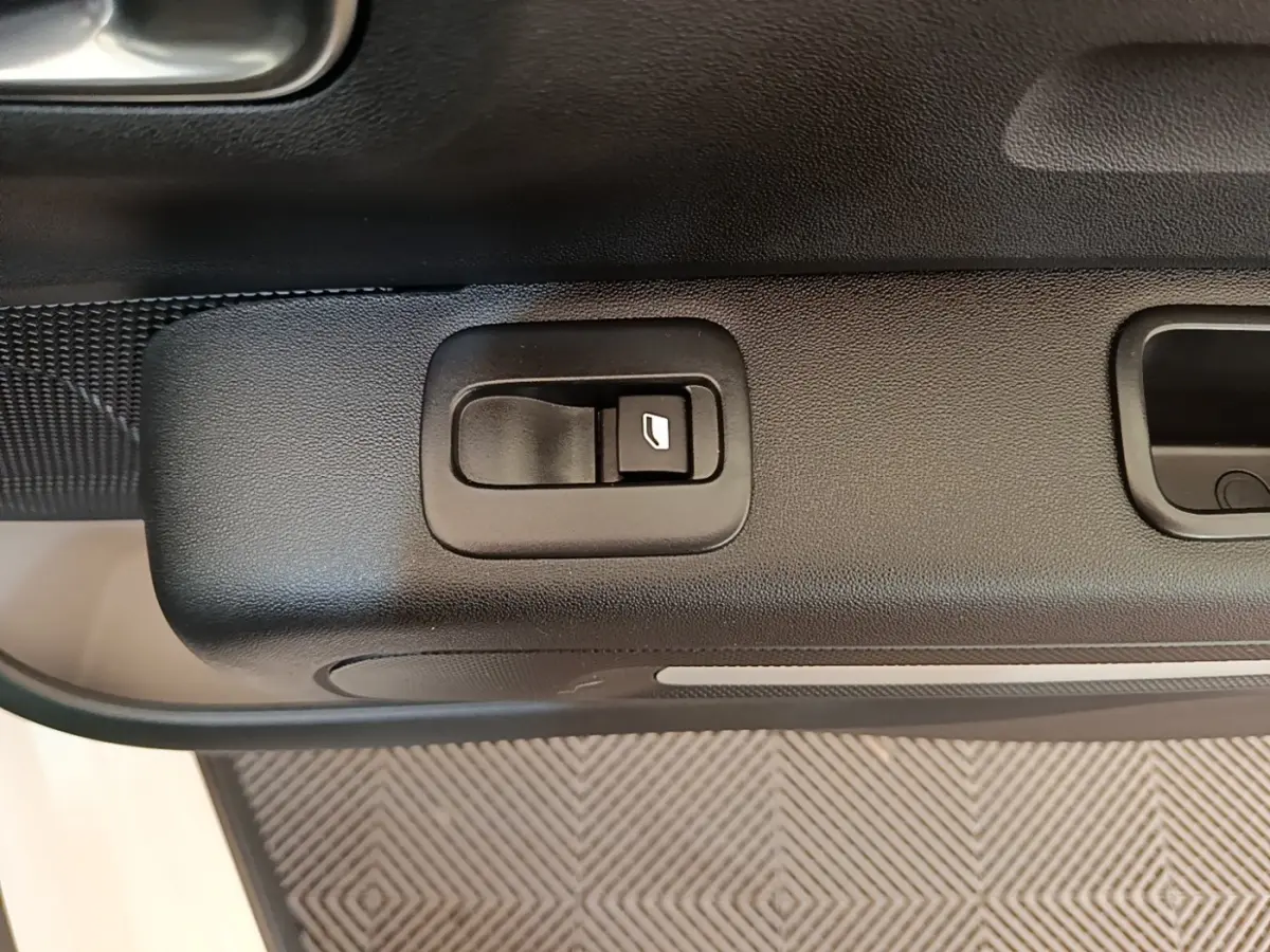 Gros plan sur la commande de lève-vitre côté conducteur de la Citroën C3 blanche de 2019.