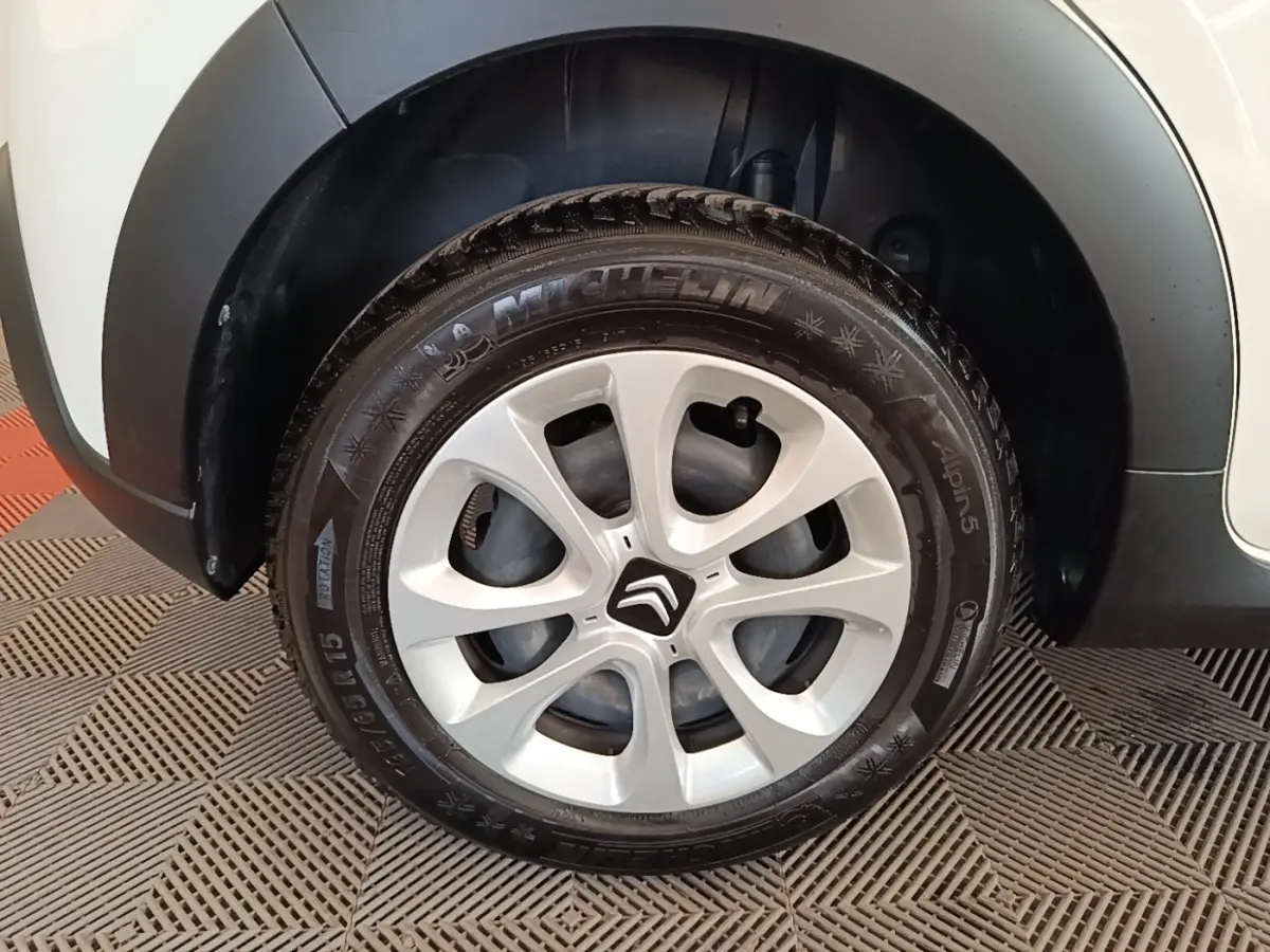 Gros plan sur la roue avant droite blanche d'une Citroën C3 2019 avec jante argentée et logo Citroën central.