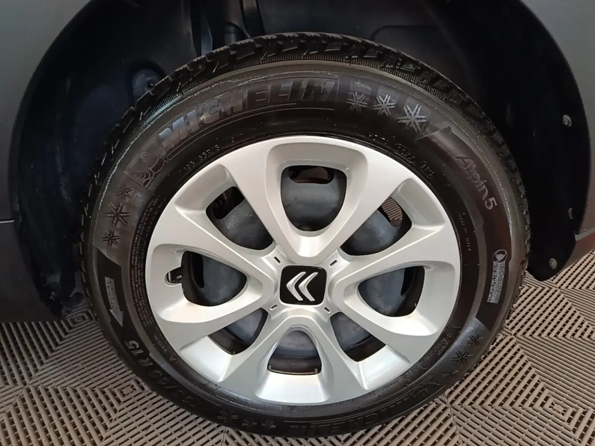 Gros plan sur la roue avant droite d'une Citroën C3 blanche, avec jante en alliage et logo Citroën central.