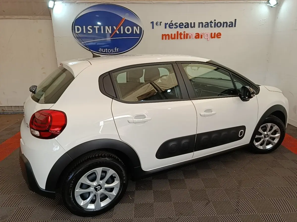 Vue côté droit d'une Citroën C3 blanche de 2019 avec protections latérales noires et jantes argentées.
