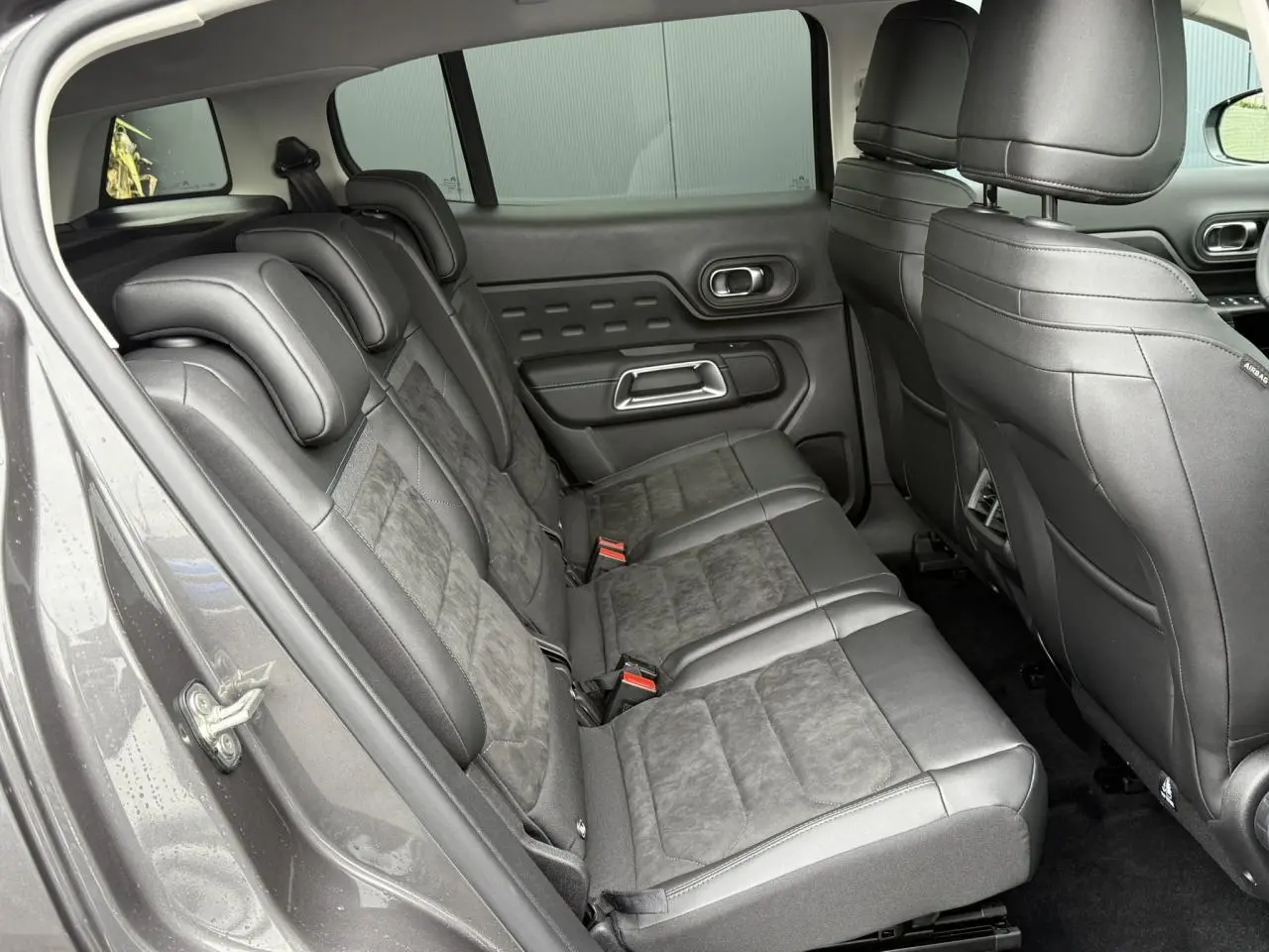Vue côté gauche des sièges arrière noirs en Alcantara et tissu effet cuir du Citroën C5 Aircross Hybrid 2025.