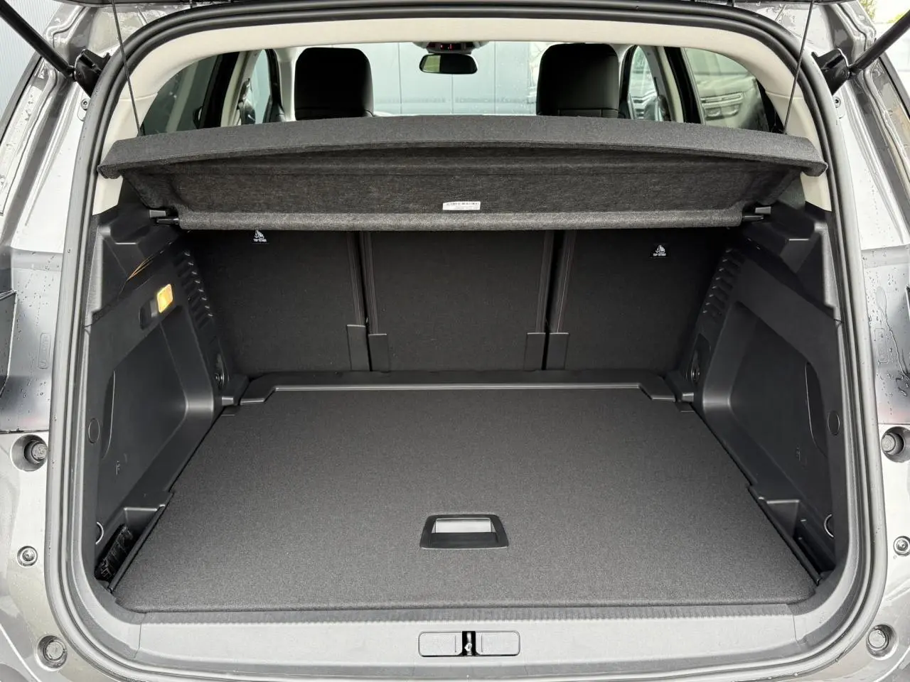 Coffre ouvert vu de l'arrière d'un Citroën C5 Aircross noir Perla, espace de chargement propre et modulable.