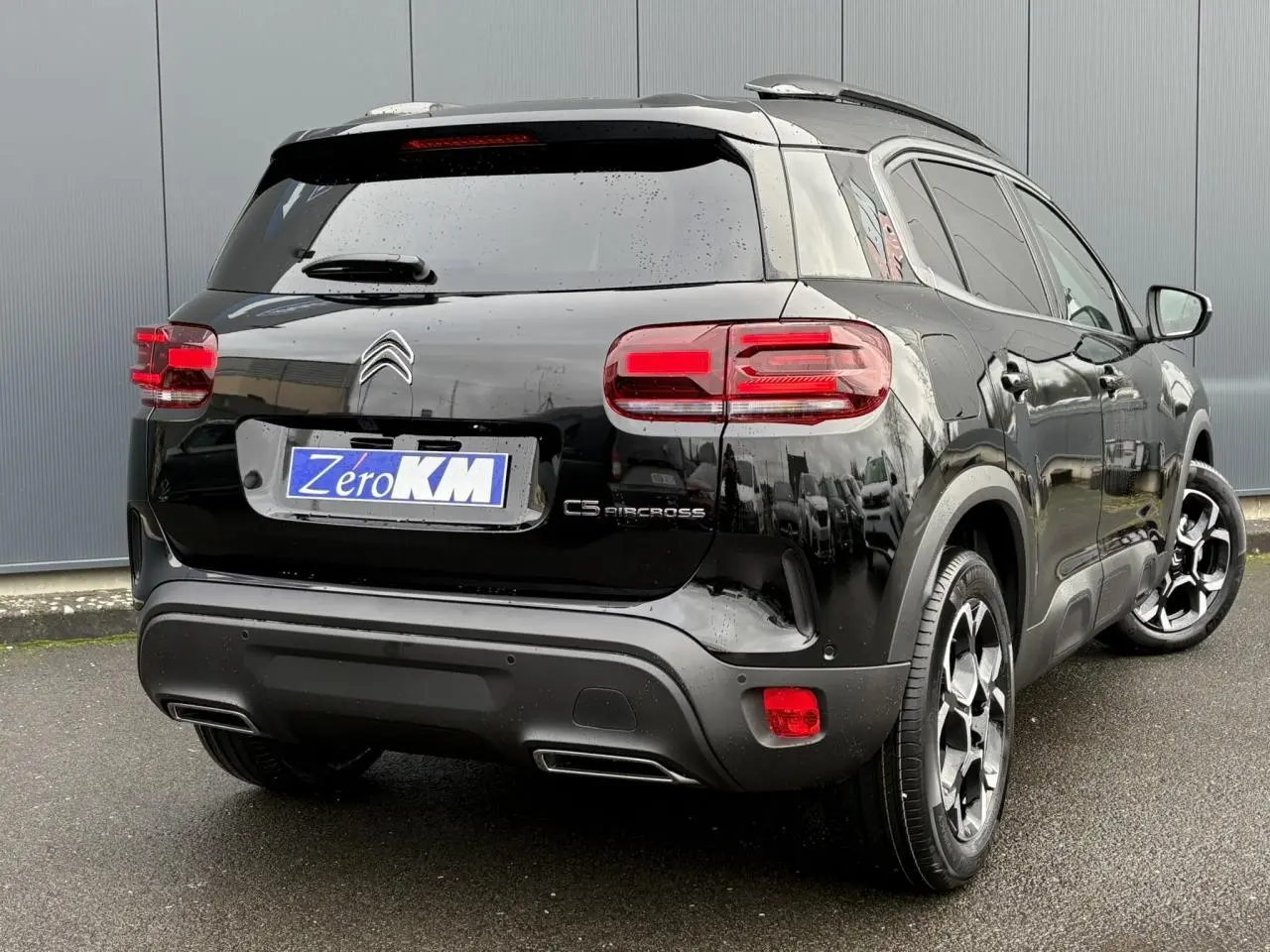Vue 3/4 arrière droite d'un Citroën C5 Aircross Hybrid noir Perla avec jantes bi-ton et feux arrière LED 3D.