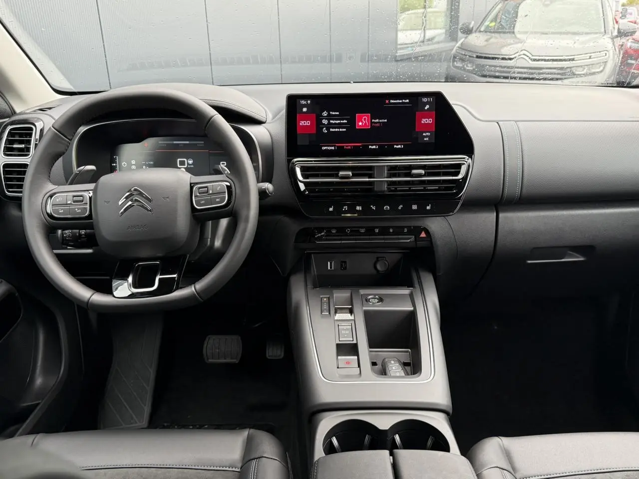 Habitacle noir du Citroën C5 Aircross Hybrid 2025, vue frontale sur le volant, tableau de bord et écran tactile 10 pouces.