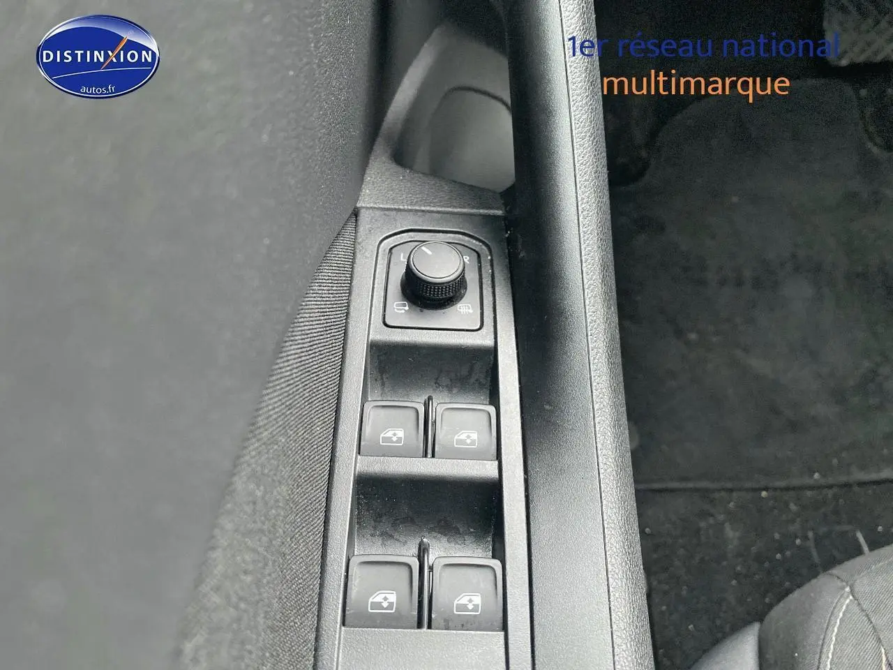 Gros plan sur les commandes de lève-vitres et réglage des rétroviseurs côté conducteur d’un Skoda Kamiq noir.