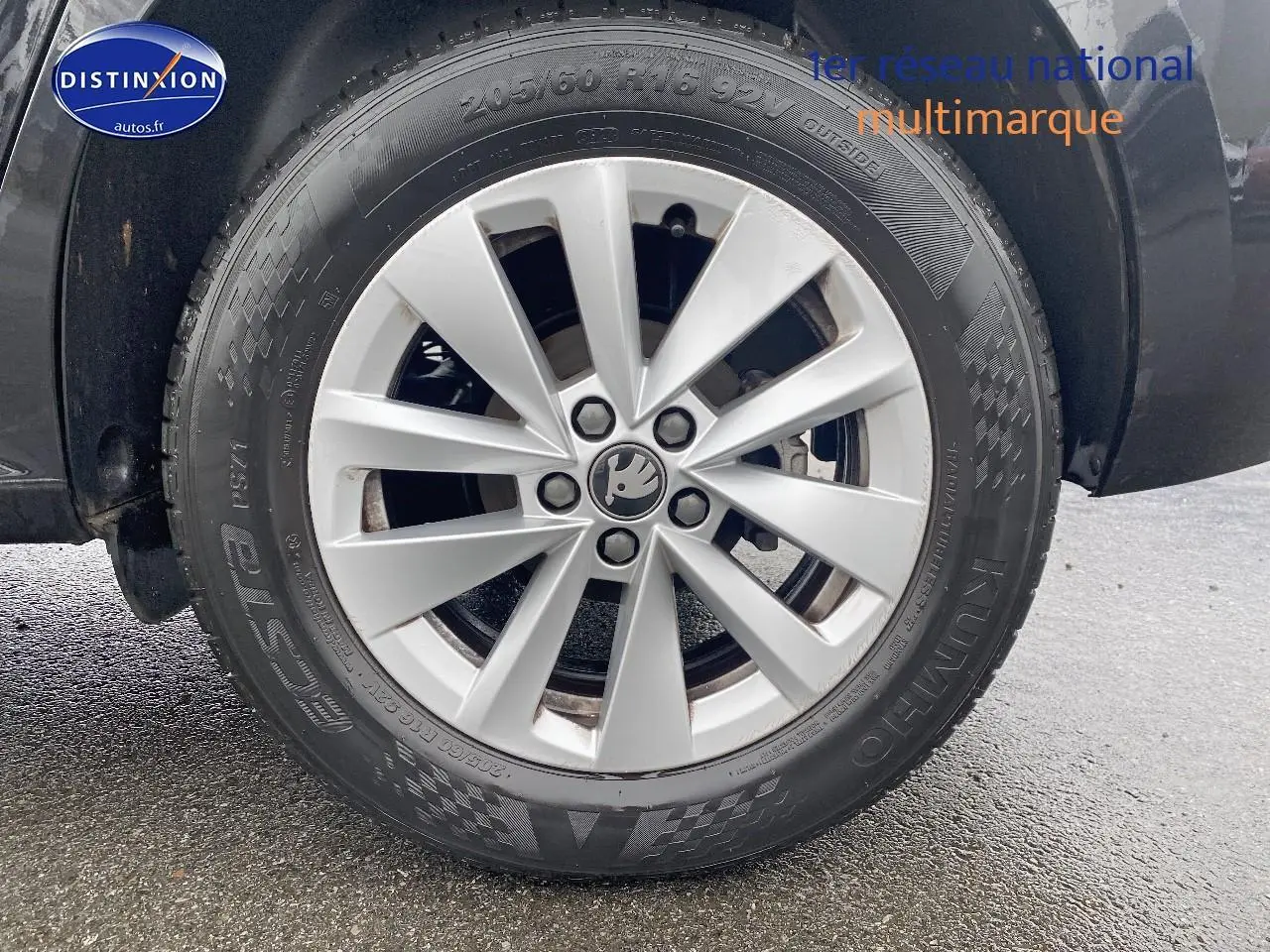 Gros plan sur la jante alu argentée et le pneu noir d'un Skoda Kamiq noir, côté gauche arrière.