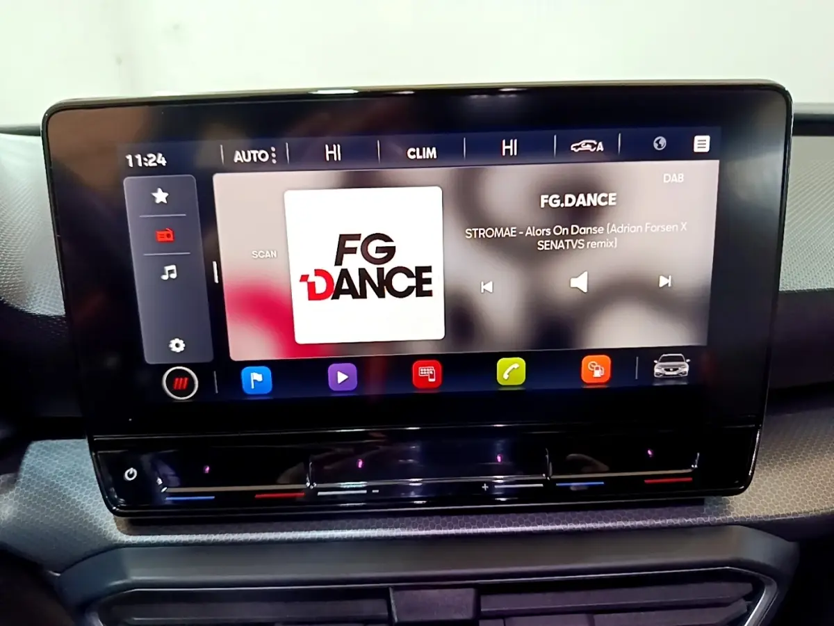 Écran tactile central du tableau de bord du SEAT Leon gris foncé, affichant une station radio FG.DANCE.