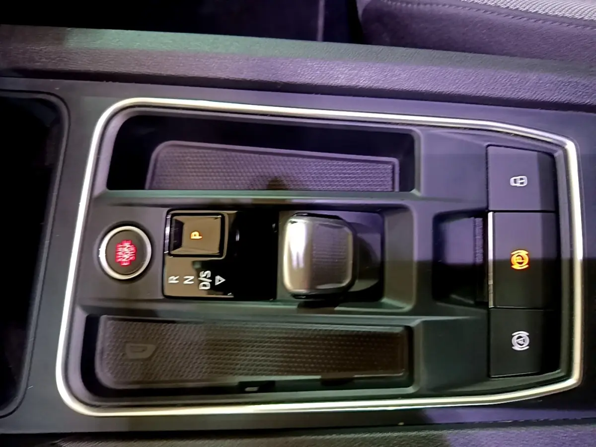 Gros plan sur la console centrale de la SEAT LEON 2022, avec bouton démarrage rouge et levier de boîte automatique.