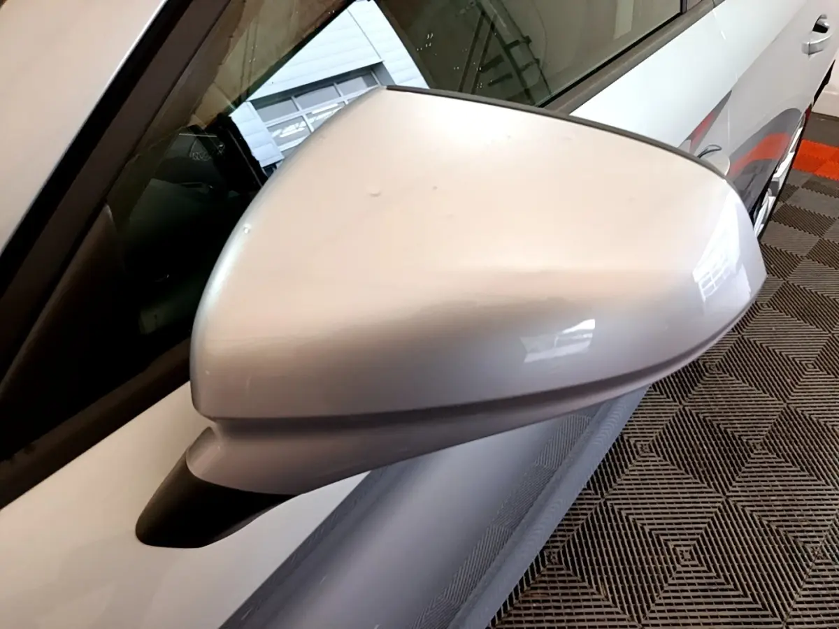Gros plan sur le rétroviseur côté conducteur gris clair du SEAT Leon 2022, avec partie de la portière visible.