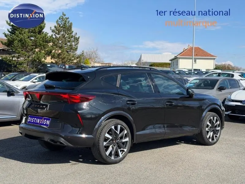 Vue 3/4 arrière droite d'un CUPRA Formentor 1.5 eTSI Hybrid noir minuit métallisé avec jantes distinctives en concession.
