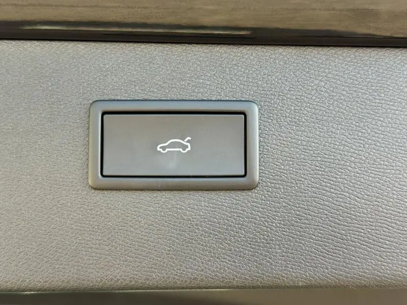 Bouton d'ouverture du coffre sur panneau intérieur texturé, détail de l'habitacle du CUPRA Formentor 1.5 eTSI Hybrid 2025.