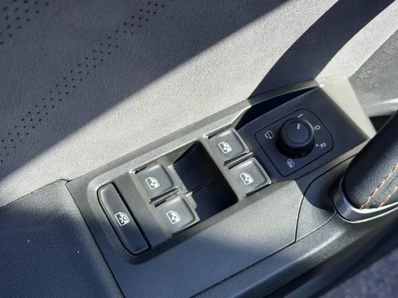 Gros plan sur les commandes des vitres électriques et rétroviseurs du côté conducteur du CUPRA Formentor 1.5 eTSI Hybrid 2025.