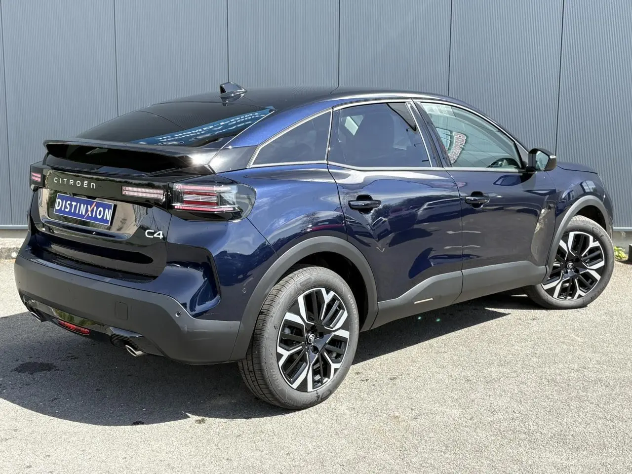 Vue 3/4 arrière droite du Citroën C4 Hybrid 145 bleu Eclipse avec jantes alliage 18 pouces et toit noir brillant.