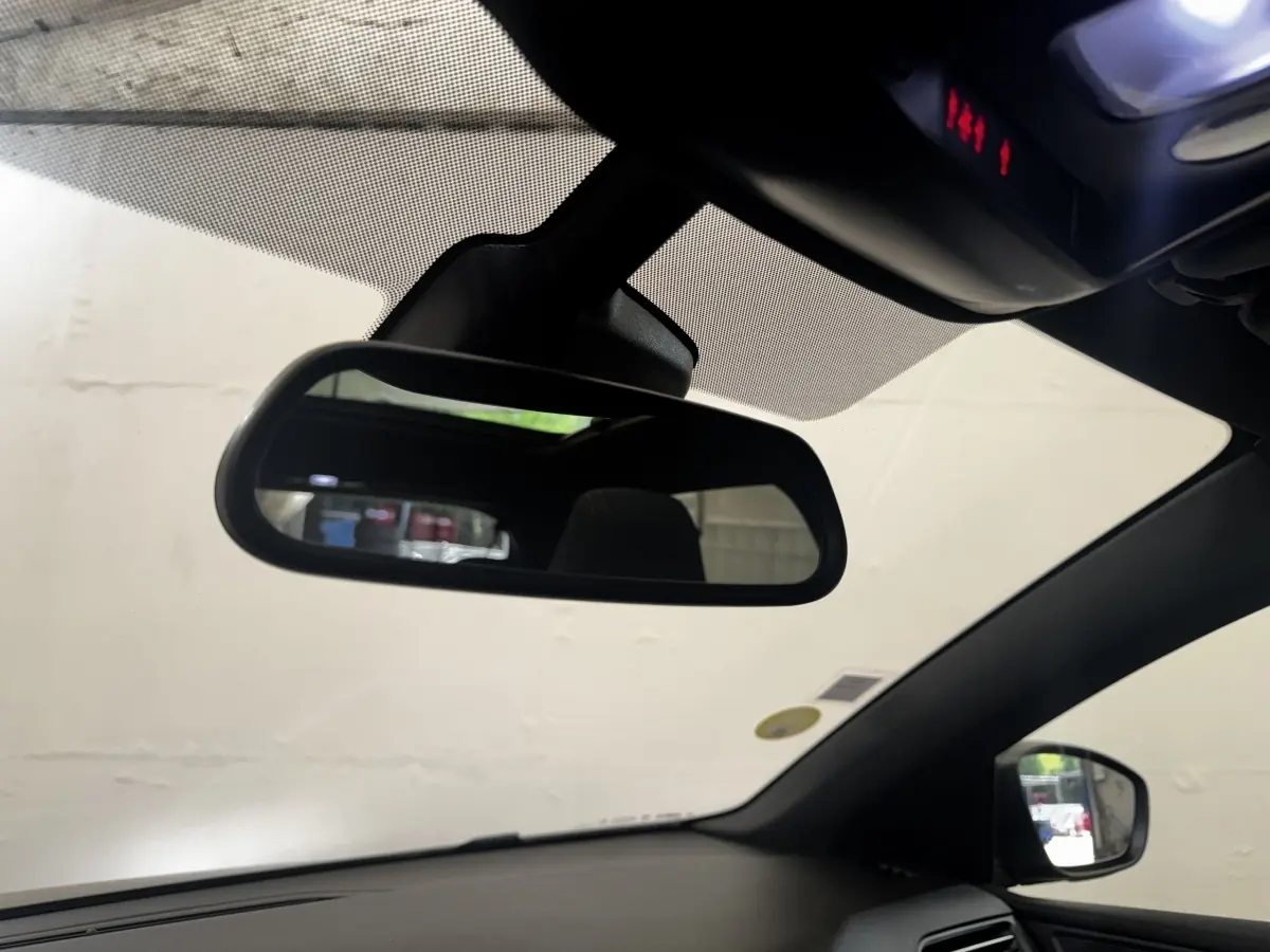 Vue intérieure du rétroviseur central et du côté droit de la Peugeot 308 noire, avec pare-brise et ciel de toit visibles.