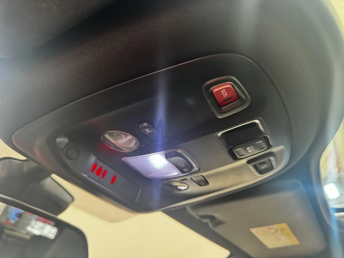 Vue intérieure en gros plan du plafonnier avec commandes d’éclairage et bouton SOS dans une Peugeot 308 noire.