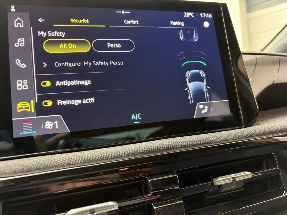 Écran tactile intérieur de la Renault Clio blanche 2026 montrant les réglages de sécurité et climatisation.