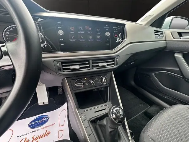 Vue intérieure côté conducteur de la Volkswagen Polo VI Lounge Business 2021, avec tableau de bord moderne et levier de vitesses manuel.