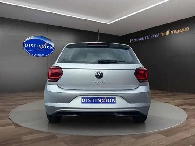 Vue arrière d'une Volkswagen Polo VI Lounge Business gris clair, stationnée en intérieur sur un plateau rotatif.