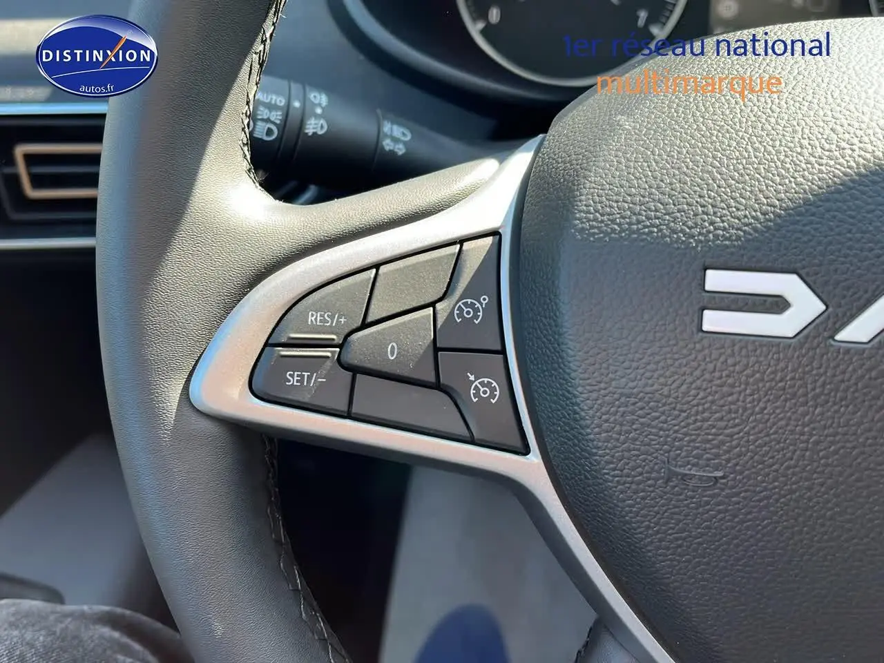 Gros plan sur les commandes de régulateur de vitesse au volant d'une Dacia Sandero 2025 vert cèdre.