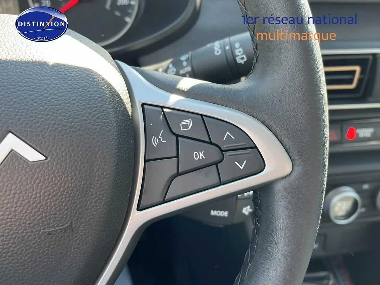 Gros plan sur les commandes au volant à droite du tableau de bord d'une Dacia Sandero 2025.