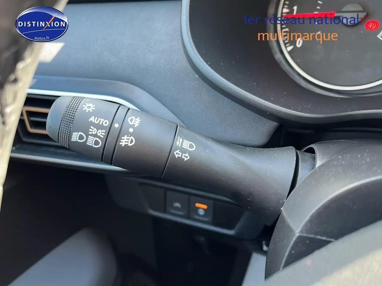 Gros plan sur la commande des phares et clignotants à gauche du volant dans l'habitacle d'une Dacia Sandero 2025.