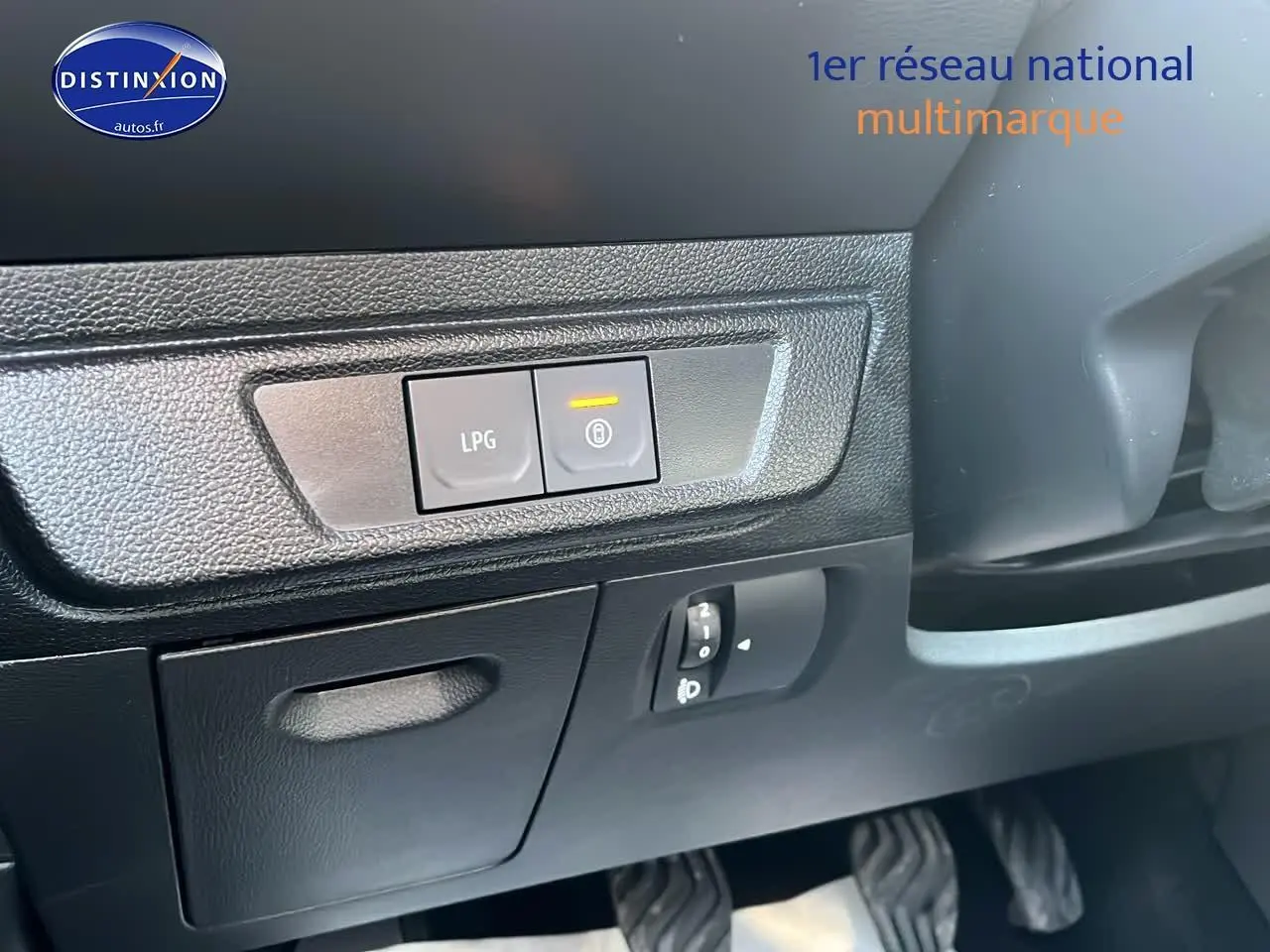 Gros plan sur les commandes LPG et verrouillage, côté gauche du tableau de bord noir de la Dacia Sandero 2025 vert cèdre.