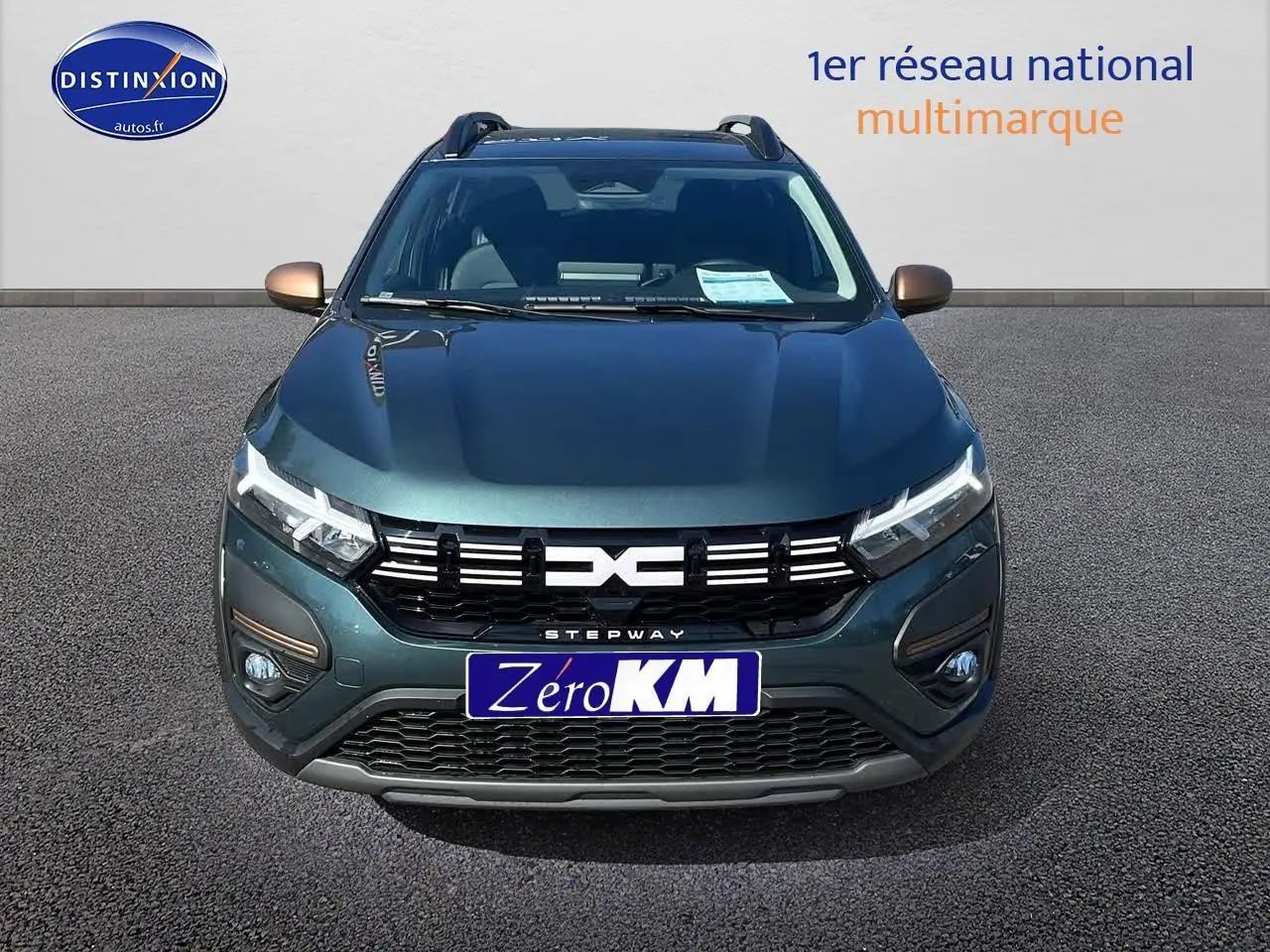 Vue frontale d'une Dacia Sandero Stepway 2025 vert cèdre avec rétroviseurs cuivrés et calandre noire distinctive.