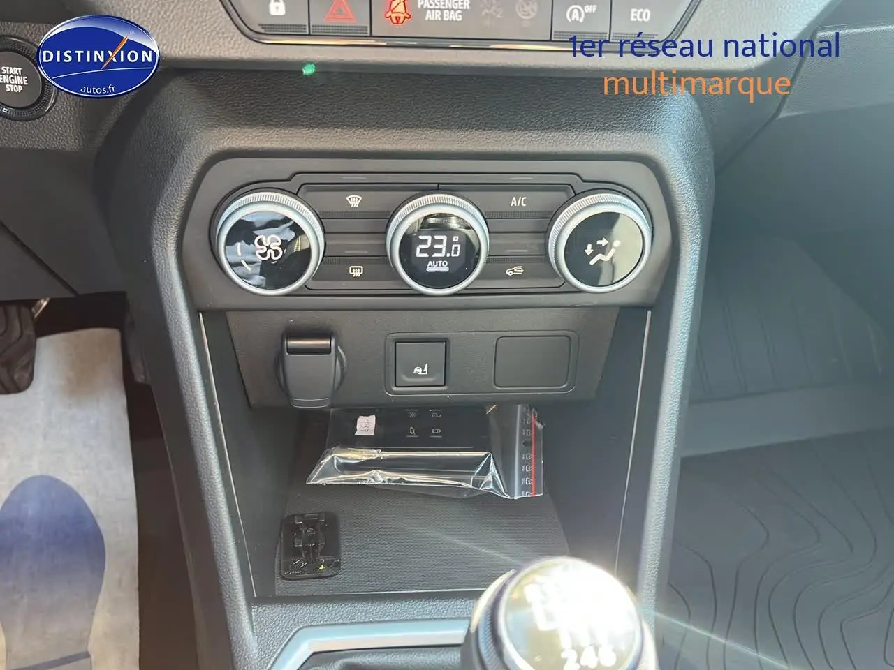 Gros plan sur la console centrale de la Dacia Sandero 2025, avec commandes climatisation et levier de vitesse manuel.