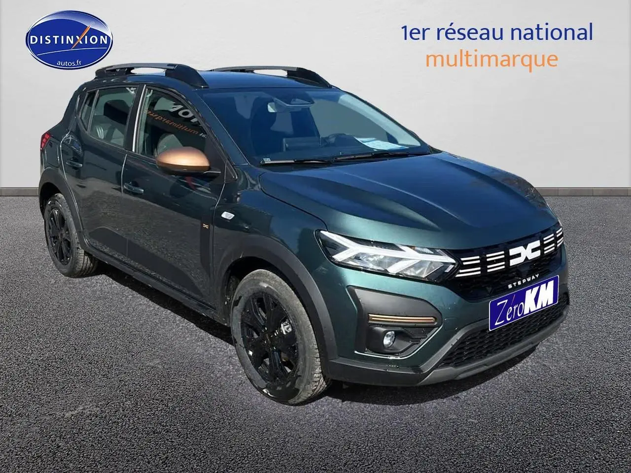 Vue 3/4 avant droite d'une Dacia Sandero Stepway 2025 vert cèdre avec rétroviseurs cuivrés et jantes noires.