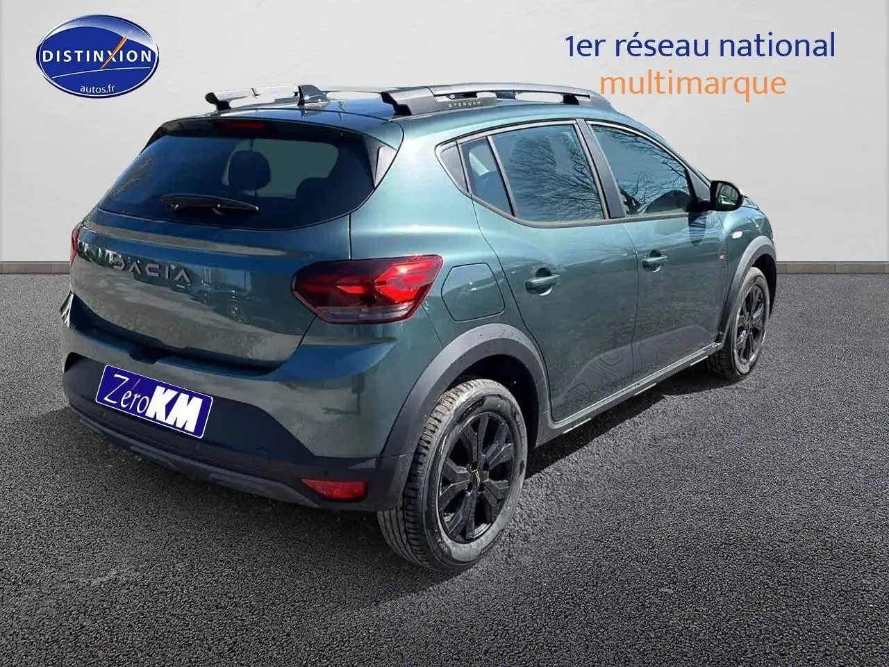 Vue 3/4 arrière droite d'une Dacia Sandero Stepway 2025 vert cèdre avec barres de toit et jantes noires.