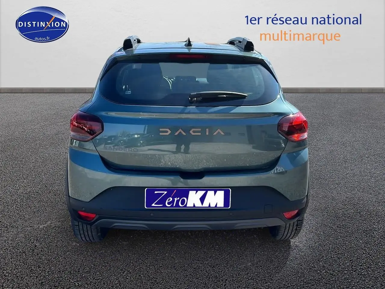 Vue arrière d'une Dacia Sandero 2025 vert cèdre avec barres de toit et becquet arrière.