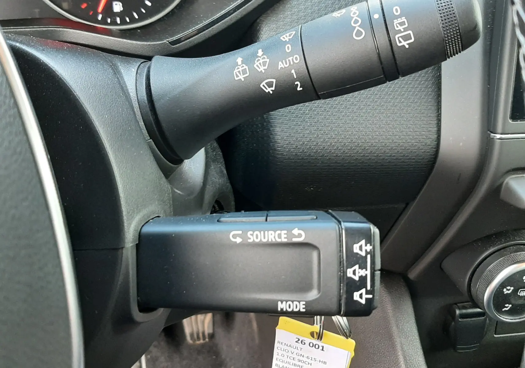 Détail du commodo gauche avec commandes d’essuie-glace et source multimédia dans une Renault Clio V blanche de 2022.