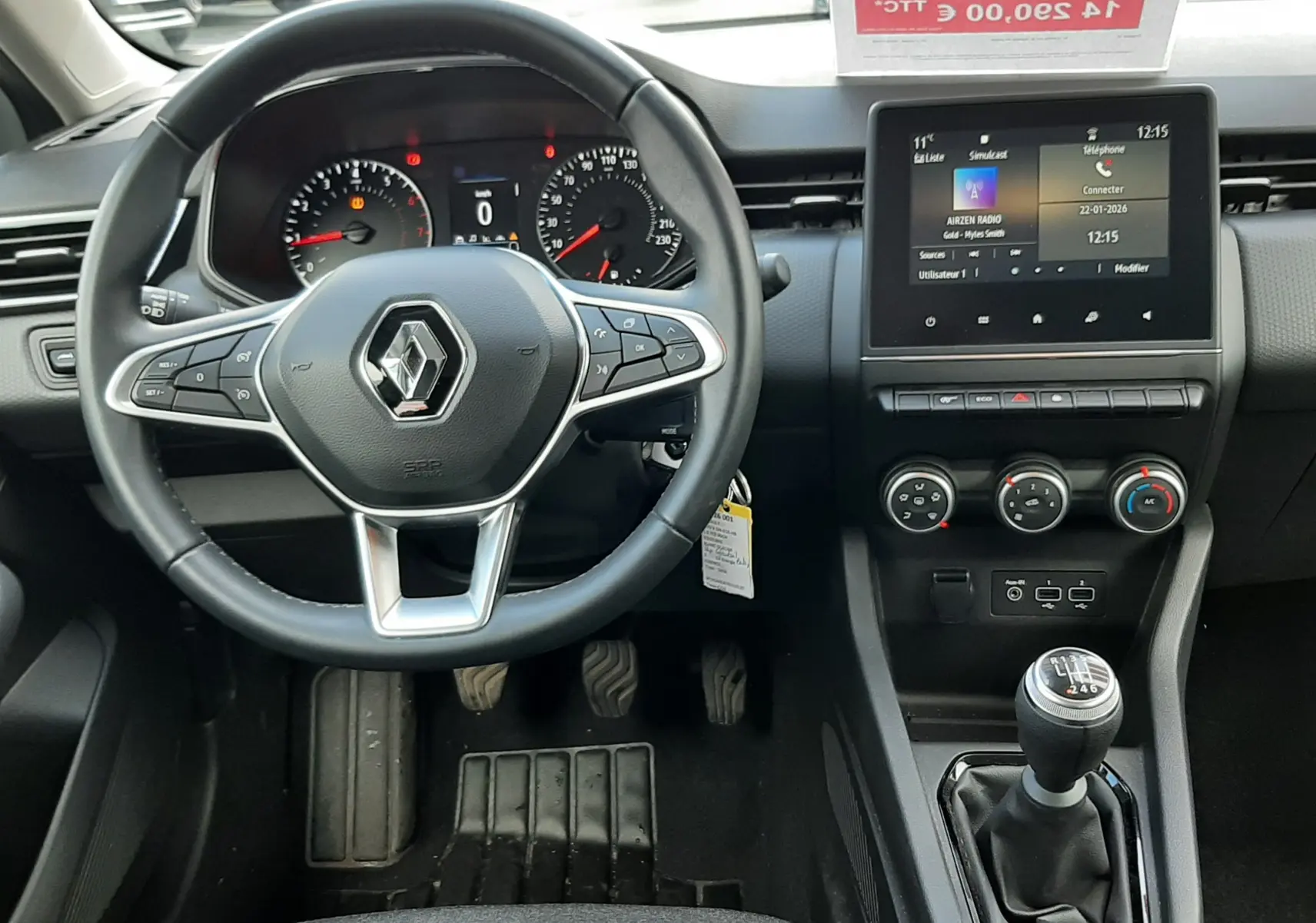 Vue intérieure avant centrée sur le volant Renault, tableau de bord numérique et levier de vitesses manuel de la Clio V 2022.