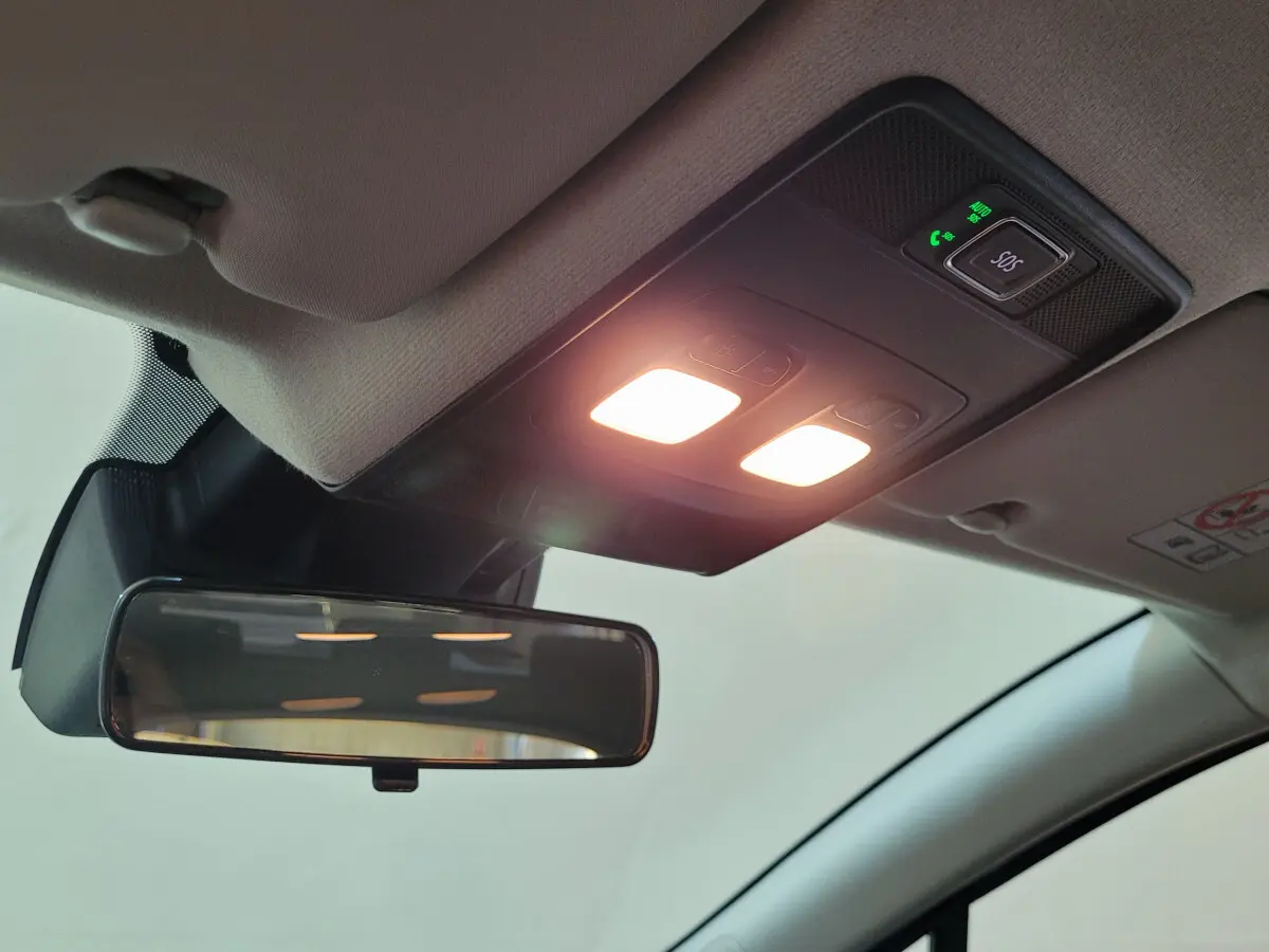 Vue intérieure du plafond avant de la Renault Clio bleu, avec rétroviseur et éclairage de lecture allumé.