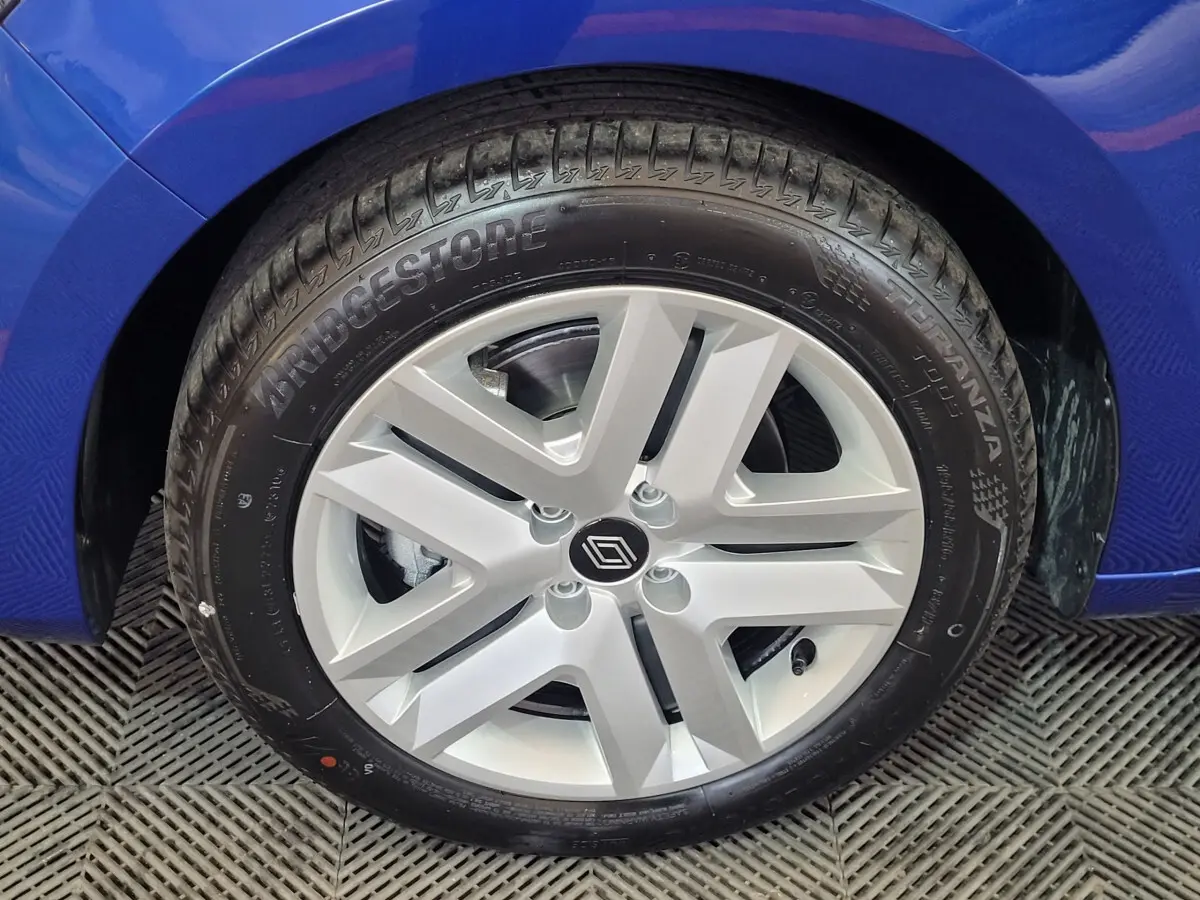 Gros plan sur la roue avant droite d’une Renault Clio bleu 2025 avec jante alliage et pneu Bridgestone.