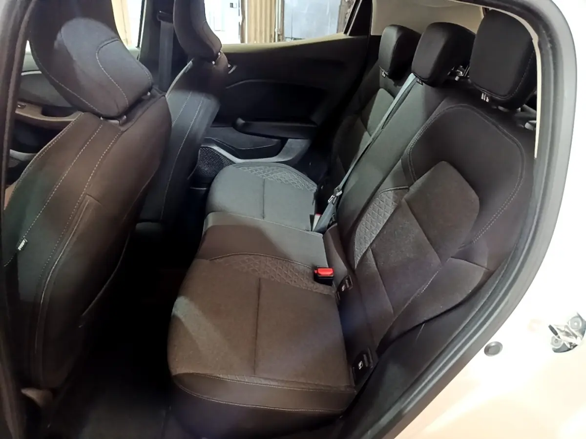 Vue intérieure côté droit sur la banquette arrière noire de la Renault Clio Business blanche, avec ceinture de sécurité visible.