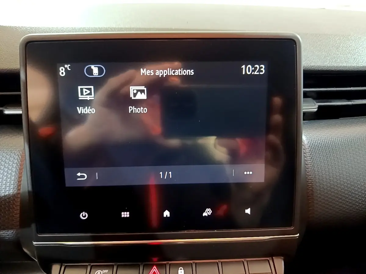 Écran tactile central affichant les applications vidéo et photo dans l’habitacle d’une Renault Clio Business blanche.